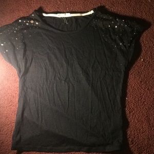 A black shirt with sequined sleeves.